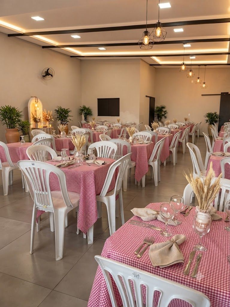 Salão decorado pela WRC com mesas de forração xadrez rosa e cadeiras brancas